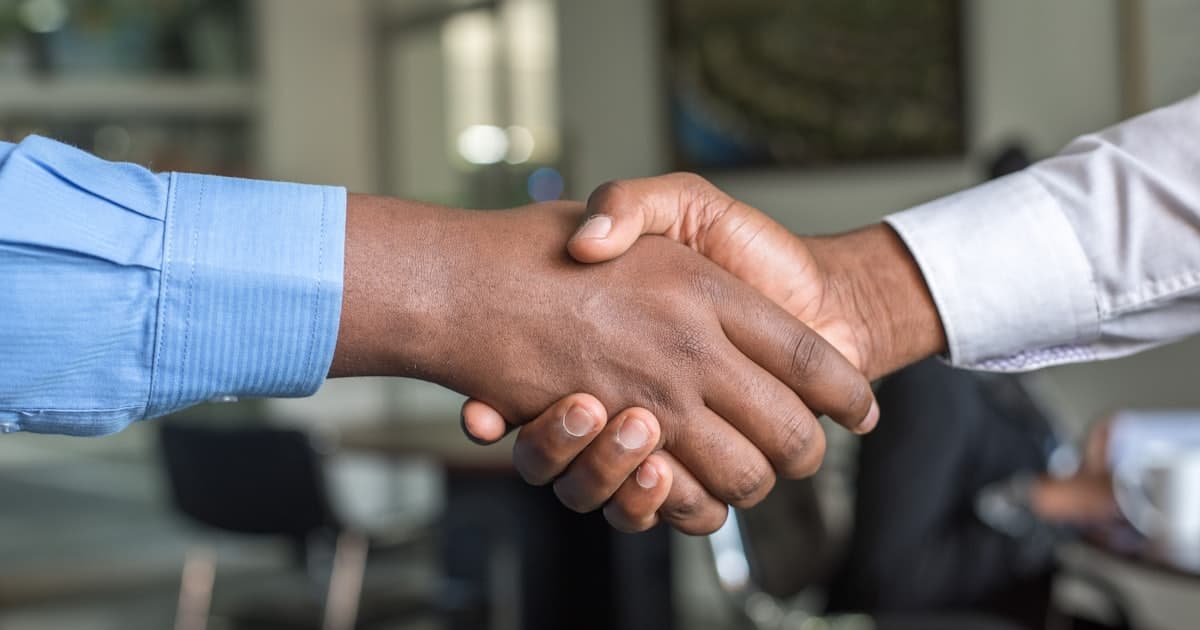 Two professionals shaking hands in an office